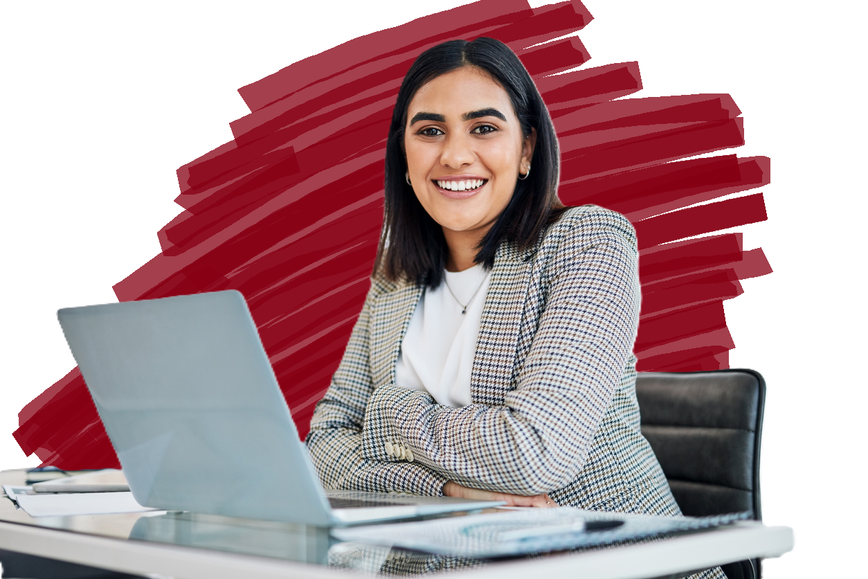 A smiling, confident female employee with a computer in front of her.